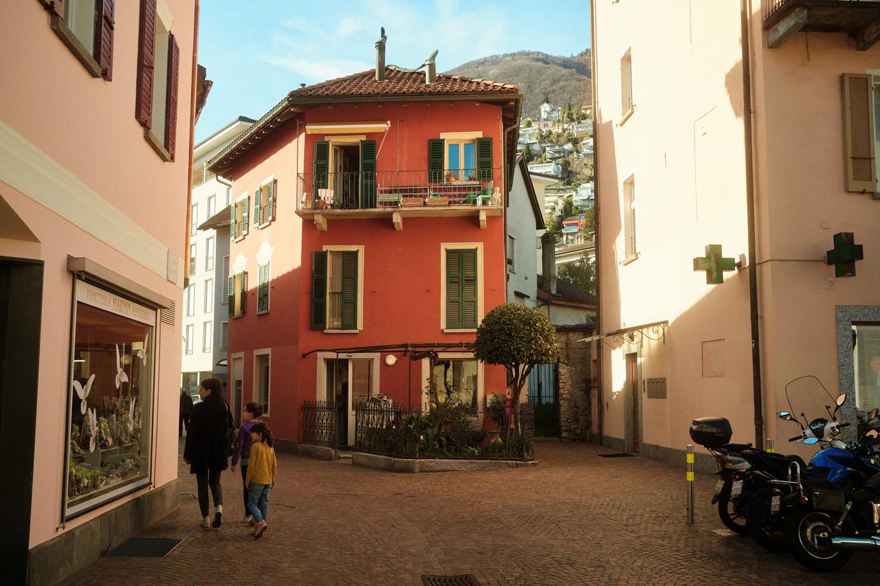 Plaza empedrada con casas de colores y contraventanas verdes